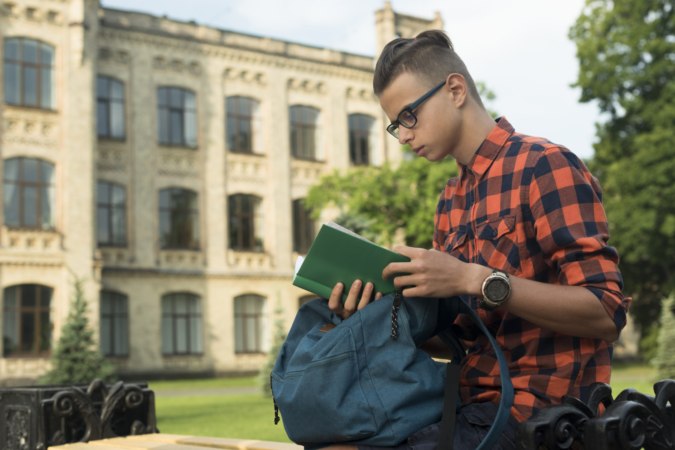 side-view-medium-shot-teenage-boy-reading-book